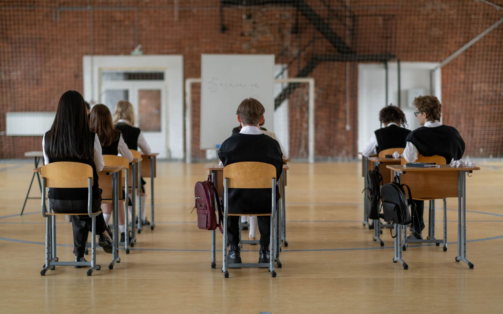 Students seated at desks in a classroom, seen from behind